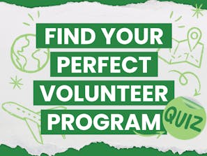 Volunteer educator pointing to notes on a whiteboard during a lesson.