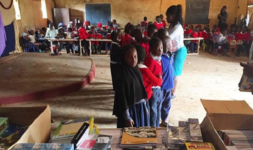 Michael Hobbs giving out pencils and workbooks to Blessed Hope children