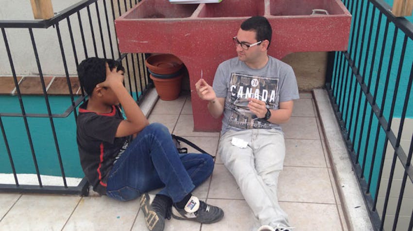 IVHQ teach and volunteer abroad scholarship winner, Armando, with a student