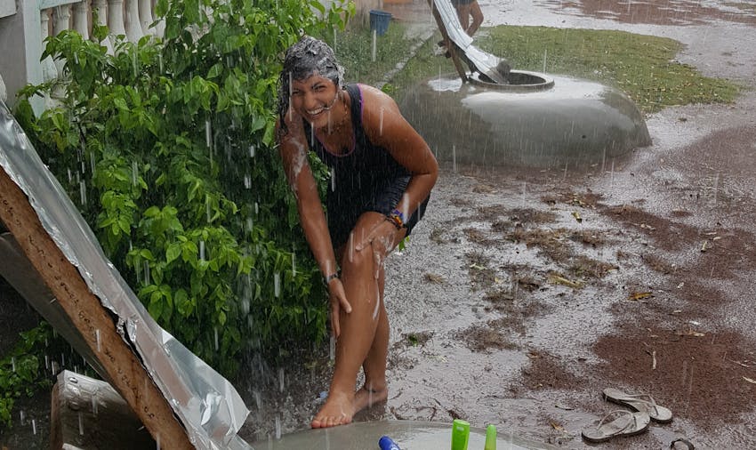 IVHQer Lara showers in the rain while volunteering in Ghana