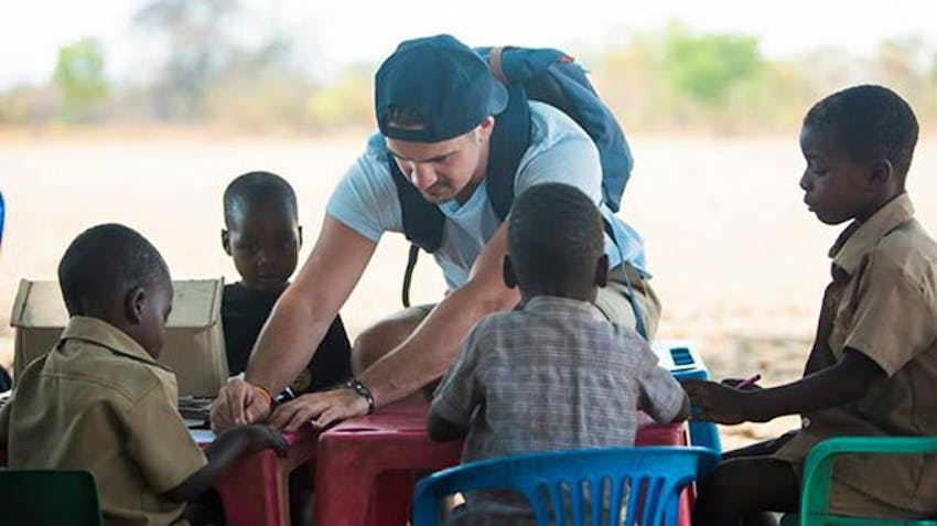 An IVHQ volunteer teaches children in Victoria Falls