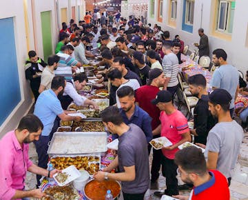 Dozens of volunteers and guests line up to enjoy an Iftar meal during Ramadan, selecting from a variety of homemade Egyptian dishes.