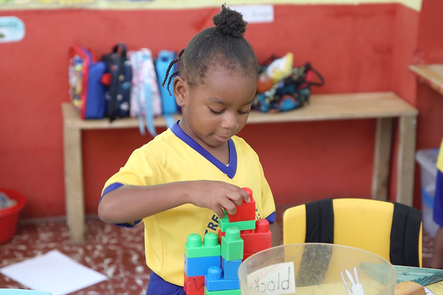 A local student playing toys at IVHQ Childcare volunteer project in Jamaica