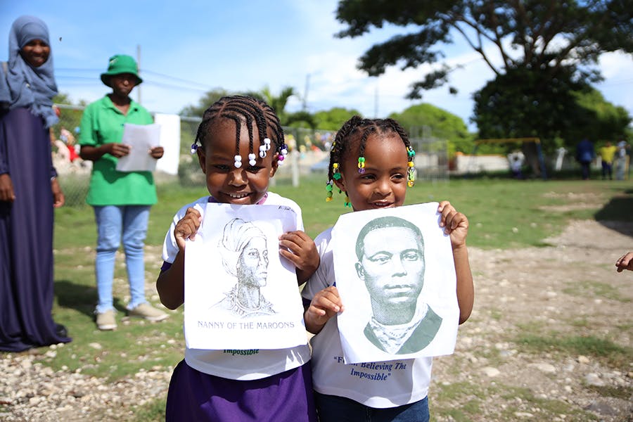 Kids showing to camera their learning in class at IVHQ Teaching and School Support project in Jamaica