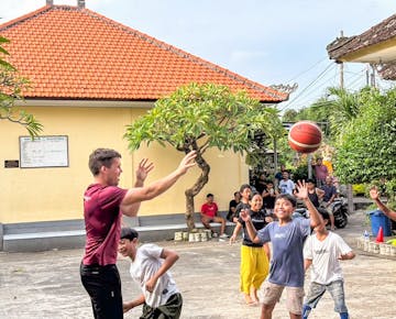Volunteers lead a group of children in an outdoor physical activity session in Lombok.