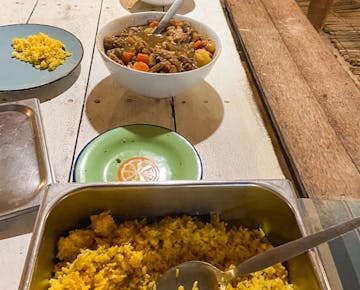 A shared meal of rice and a hearty vegetable-beef stew is served at the volunteer lodge in Mozambique during dinnertime.