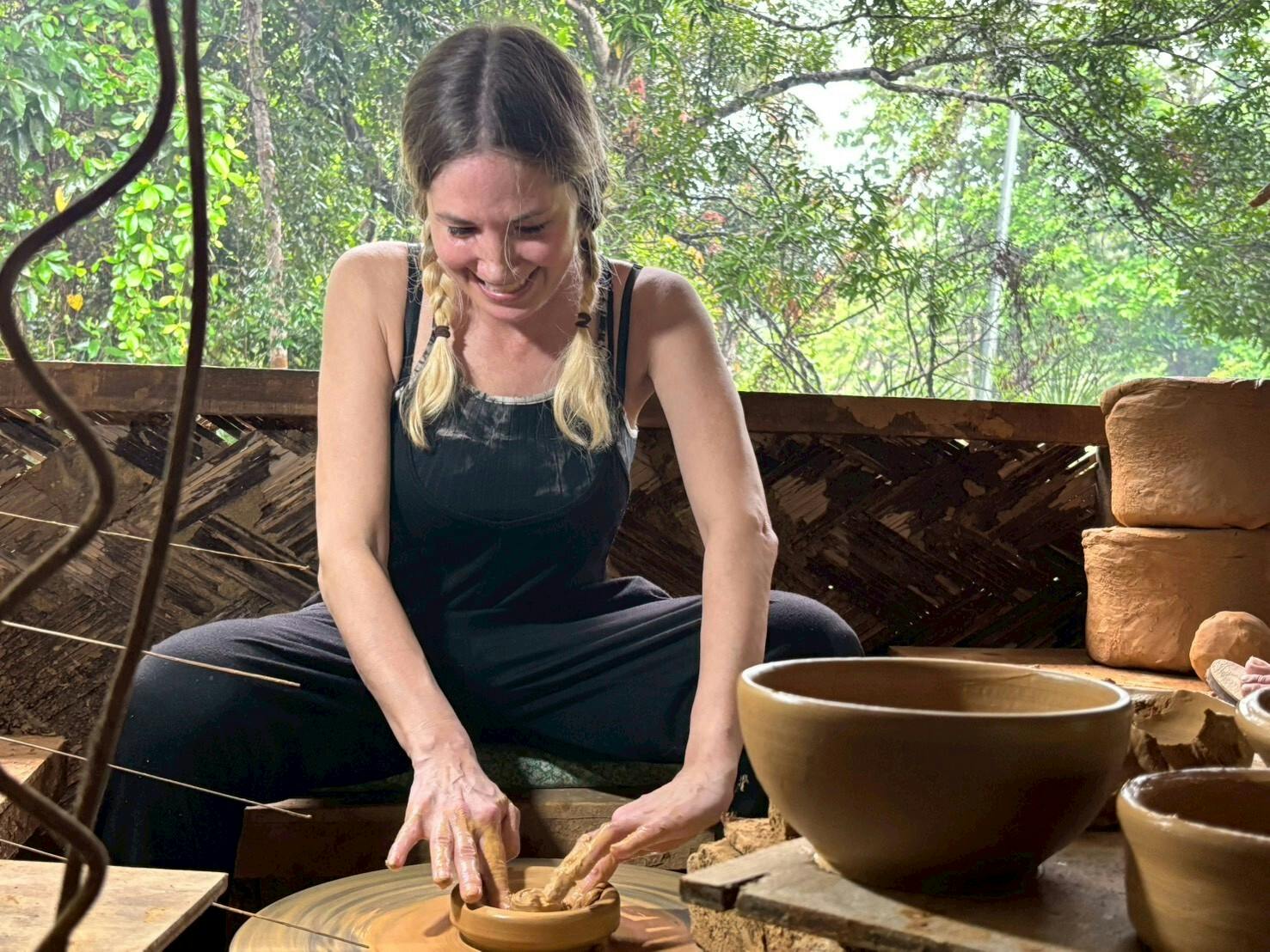 A young female volunteer sits whilst she peacefully creates pottery.
