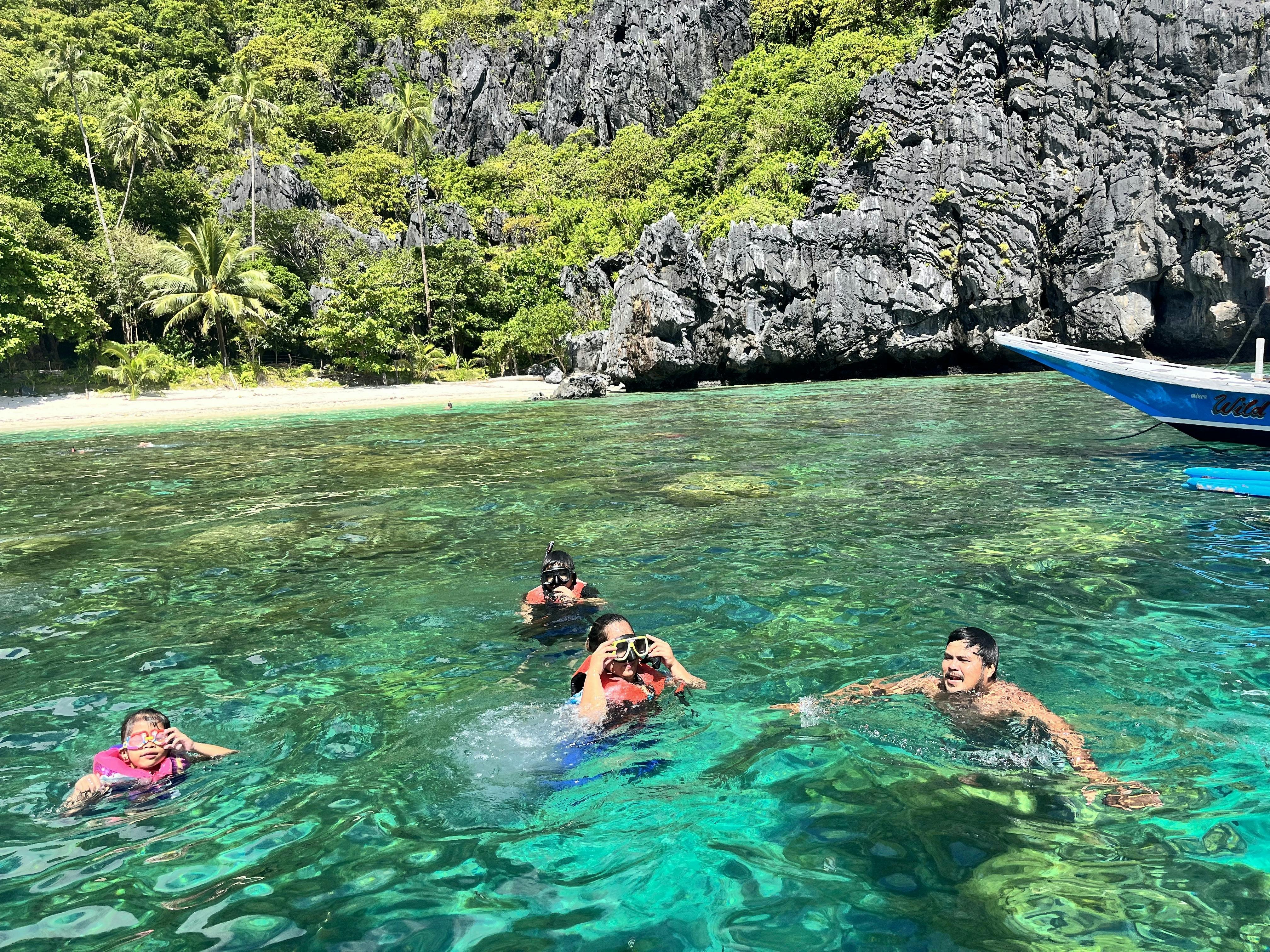 A group of volunteers take a dip in the clear blue ocean as well as participating in a snorkeling activity.