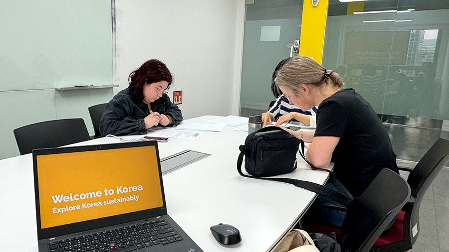 IVHQ volunteers reading the orientation documents with IVHQ South Korea local team