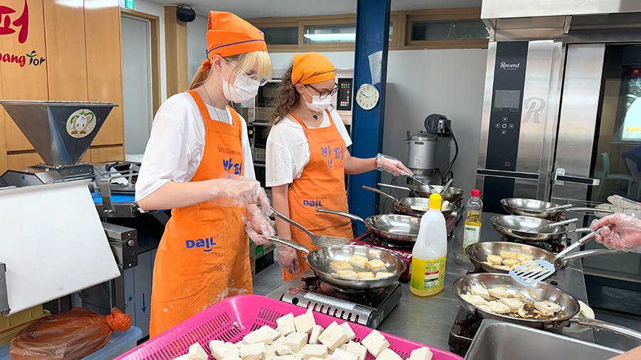 IVHQ volunteers frying tofu at the IVHQ Soup Kitchen volunteer project in South Korea