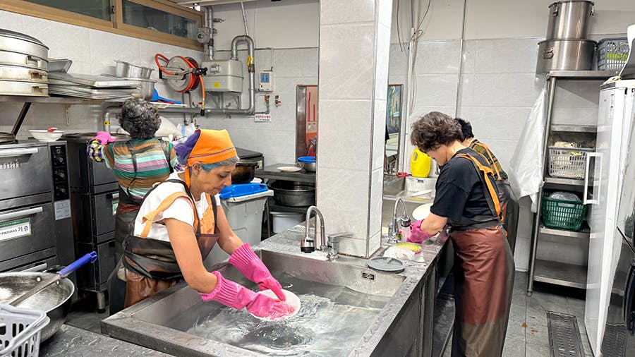 IVHQ volunteers washing dishes at the Soup Kitchen volunteer project in Seoul, South Korea