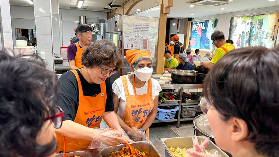 IVHQ volunteers loading and giving food to people at the Soup Kitchen volunteer project in Seoul, South Korea