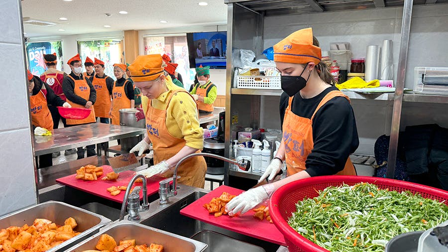 IVHQ volunteers cutting vegetables at the Soup Kitchen volunteer project in Seoul, South Korea
