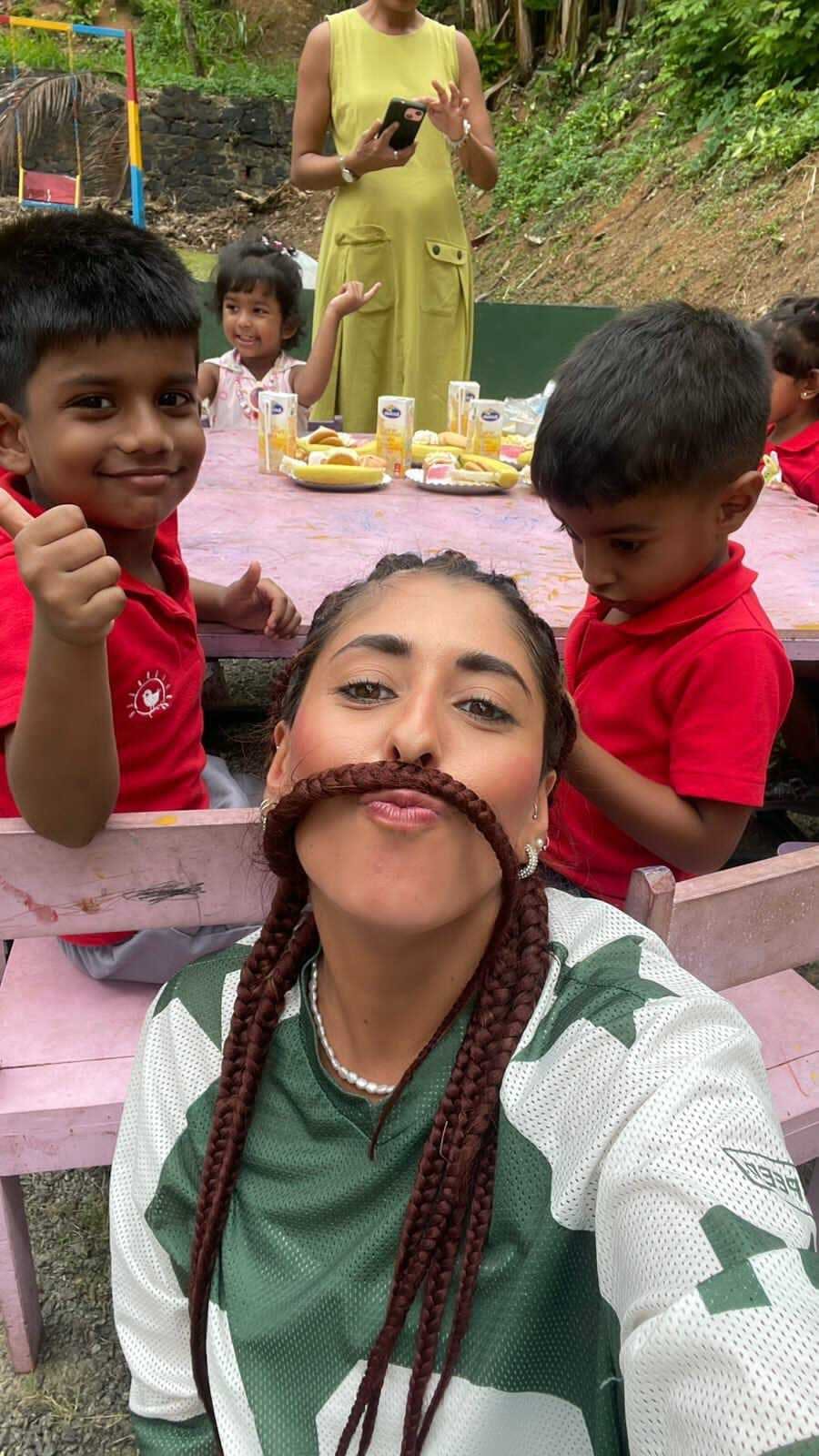 An IVHQ volunteer is playing while we learn with two children at the teaching placement!