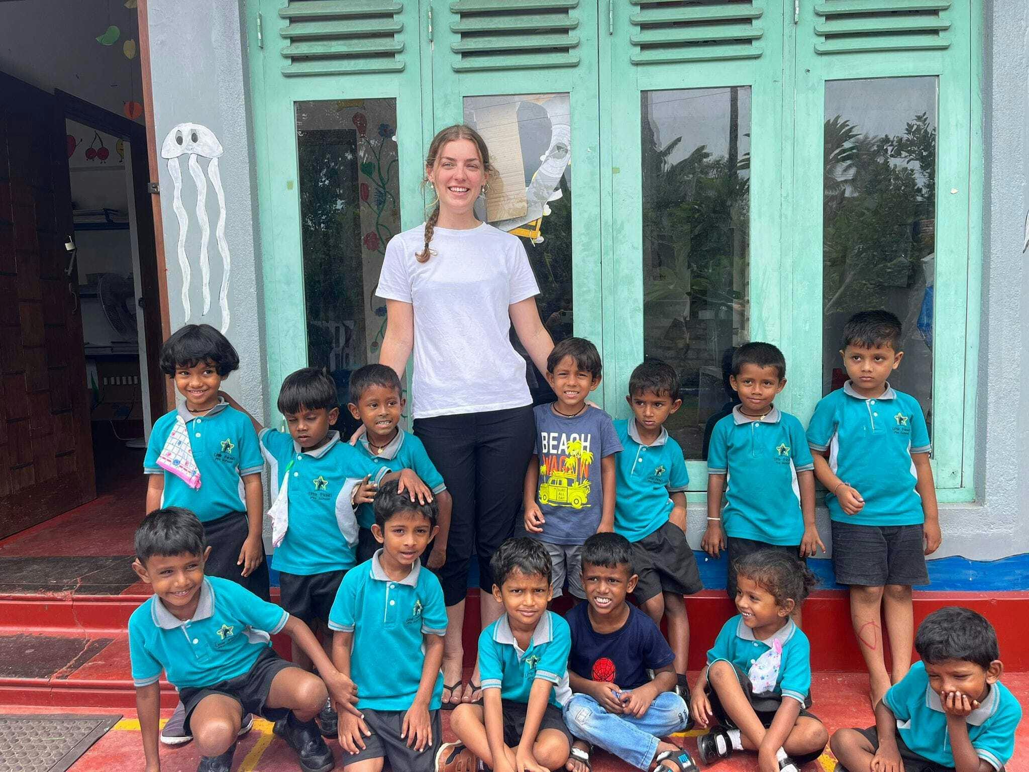 An IVHQ proud volunteer standing with her class to document her time on the Teaching project