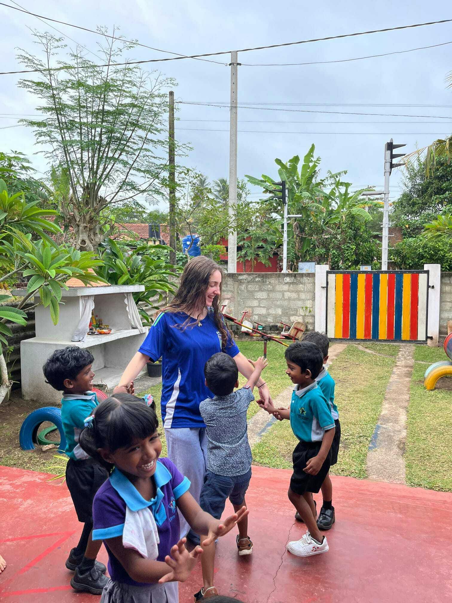 An IVHQ volunteer plays outside with children at a local kindergarten