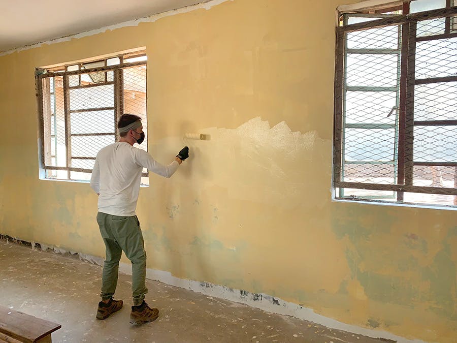 Volunteer renovating local facility at the IVHQ Tanzania construction project