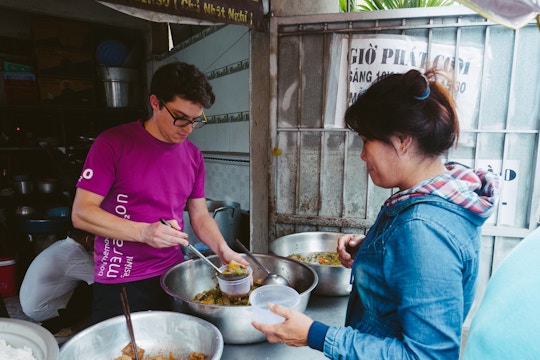 Volunteer serving food on the Food Outreach volunteers with IVHQ in Vietnam
